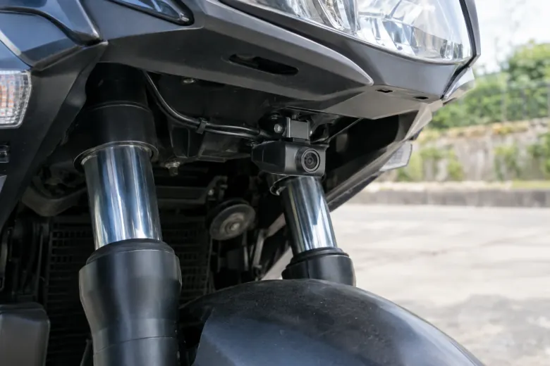 Compact camera mounted beneath a motorcycle headlight