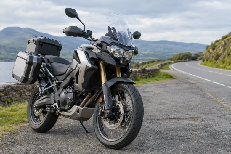 Touring motorcycle with luggage parked beside a winding road
