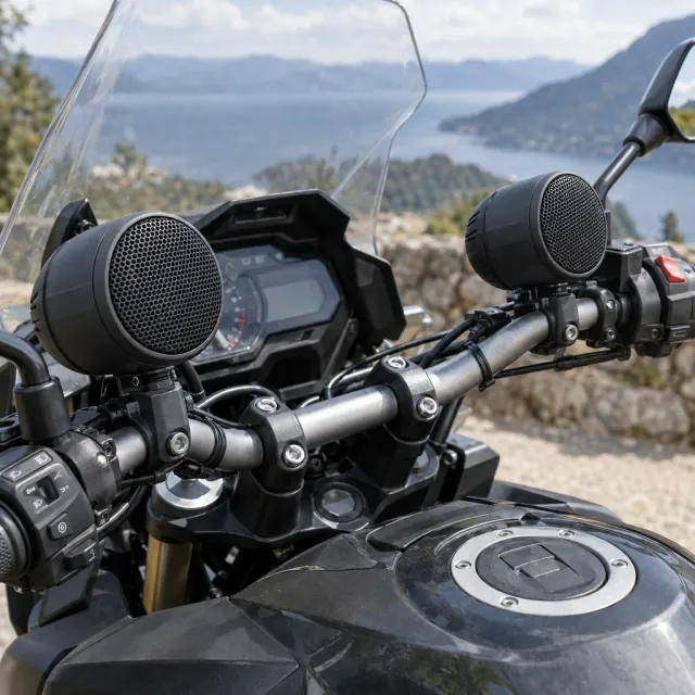 Pair of compact speakers attached to a parked motorcycle handlebar