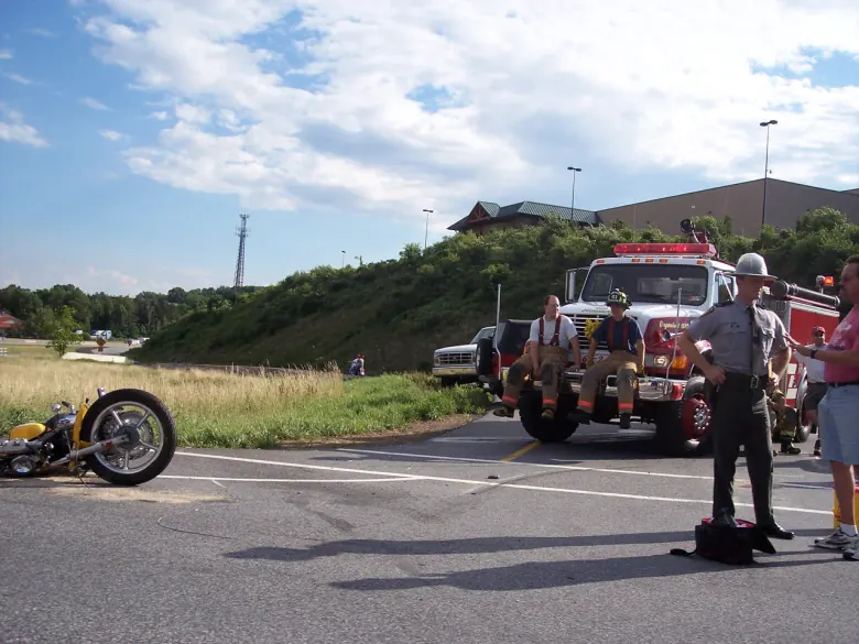 Emergency responders beside a motorcycle at a historical roadside accident